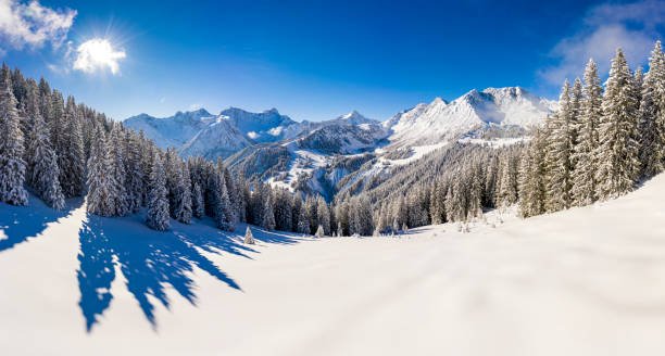 Aerial view of a snowy winter landscape and perfect conditions in ski resort in the morning. Panorama photographed in Brandnertal, Vorarlberg, Austria.